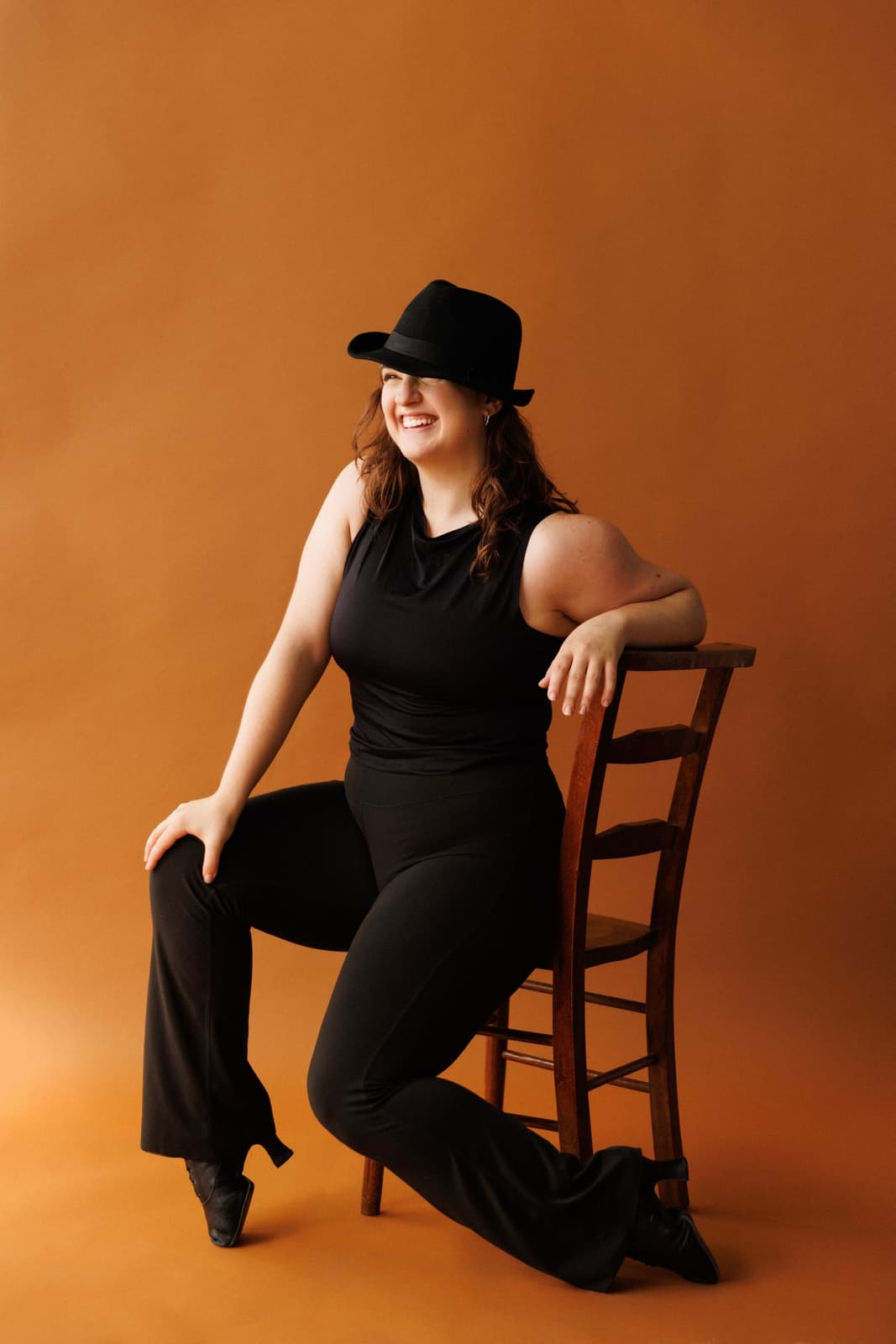 Carolyn Rupp laughing while seated on a chair in black