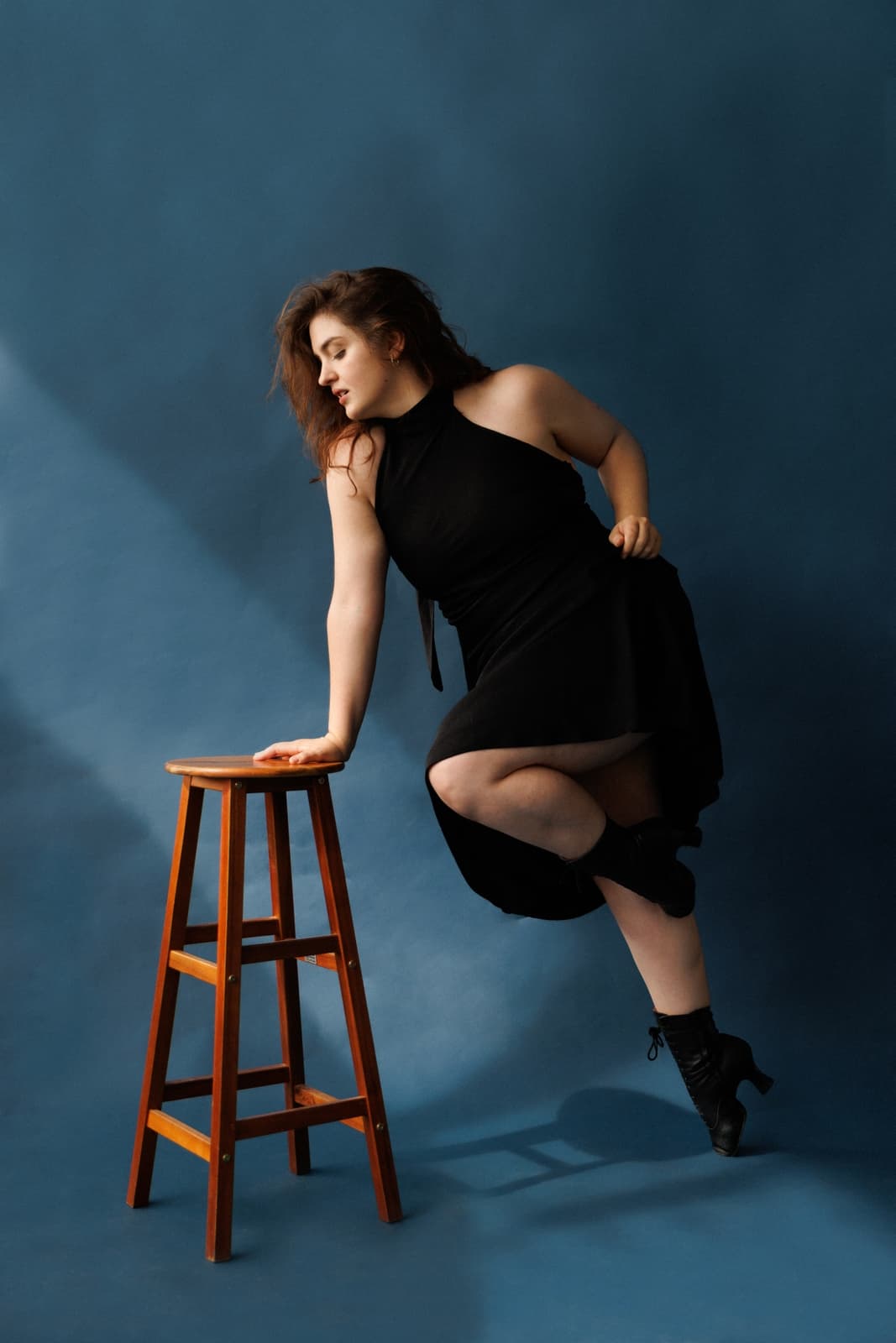 Carolyn Rupp in passé, leaning on a wooden stool