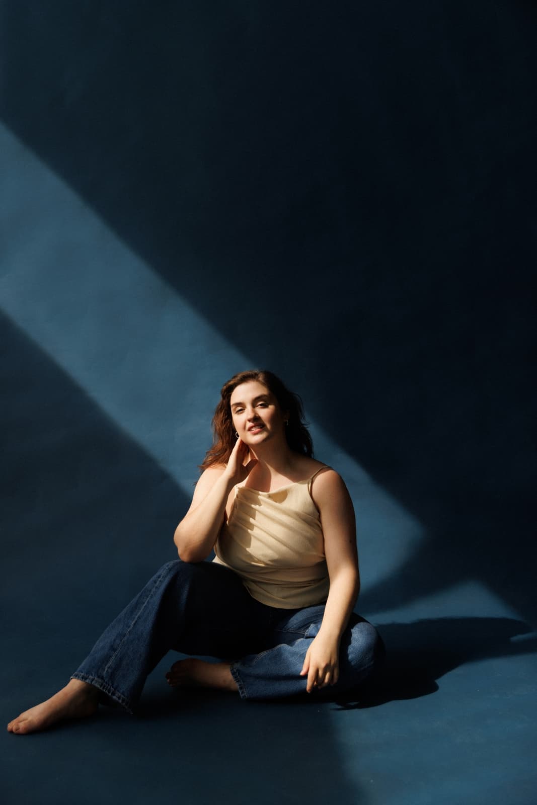 Carolyn Rupp seated on the floor in a beam of light